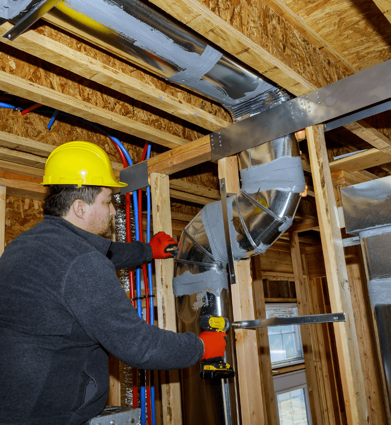 Worker installing ductwork for central air system